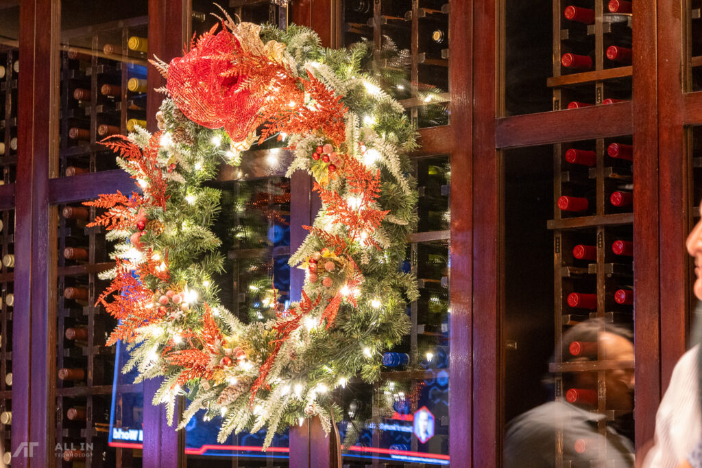 Holiday wreath with christmas lights in front of a wine cellar