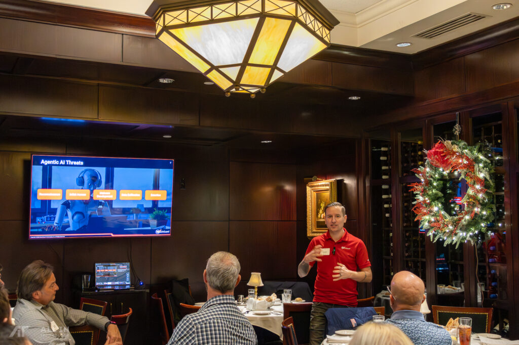 Marc Laliberte speaking in front of a group at the All in Technology and WatchGuard holiday luncheon discussing FireCloud Zero Trust