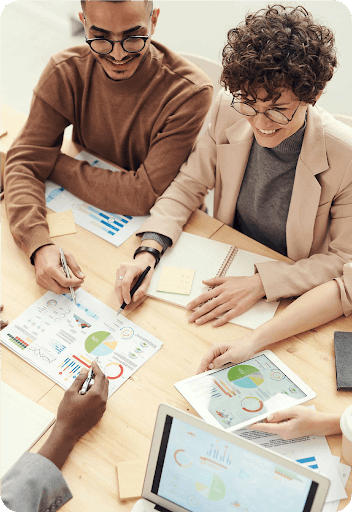 Business team smiling and looking at graphics.
